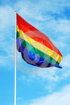 Rainbow gay pride flag on the blue sky