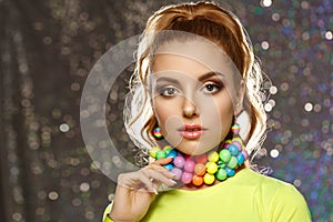 Rainbow girl. Model with colorful bright jewelry. Woman with neat makeup and high hairstyle with colored necklace and earrings