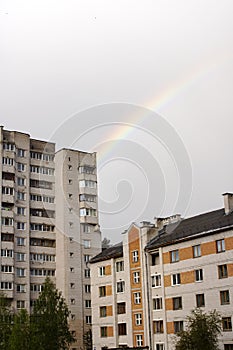 Rainbow in the gray sky over the rooftops