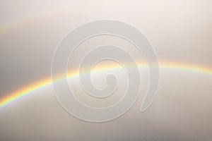 Rainbow in the gray sky over the rooftops