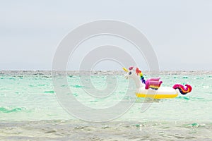 Rainbow inflatable unicorn in the sea. Enjoy the summer. Vacation and travel concept. Copy space