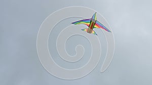 Rainbow kite flying against cloudy sky