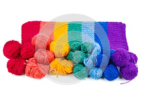 Rainbow knitted fabric and balls of wool thread isolated on white