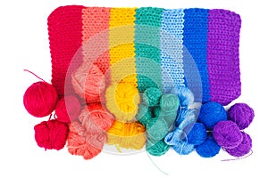 Rainbow knitted fabric and balls of wool thread isolated on white background