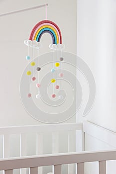 Rainbow mobile hanging on crib in baby room