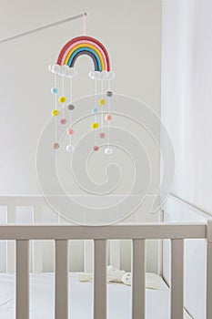 Rainbow mobile hanging on crib in baby room