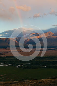 Rainbow in the mountain valley after rain. Beautiful landscape