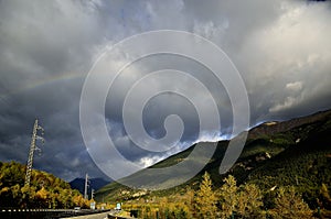 Rainbow in the mountains with very dark sky