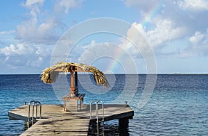 A rainbow near a palapa with a nice view of the caribbean sea