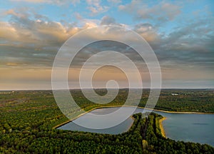 Rainbow in the nice sunset scene over a lake with forest sky