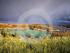 Rainbow over the azure bay during a storm in Norway