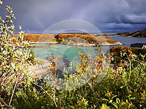 Rainbow over the azure bay during a storm in Norway