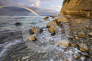 Rainbow over the cliff after passing an evening storm