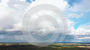 The Rainbow Over the Crop Field With Blooming Wheat, During Spring, Aerial View Under Heavy Clouds Before Thunderstorm. Agricultur