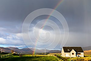 A rainbow over a cute cottage on a farm