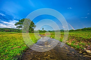 Rainbow over fields and trees and river