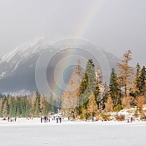 Rainbow over frozen lake in the mountains in winter