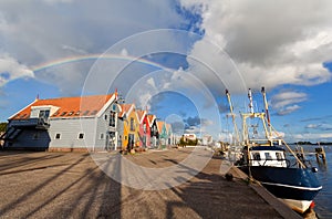 Rainbow over harbor in fishing village Zoutkamp