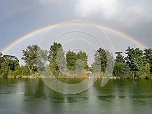 rainbow over a lake with trees in the background