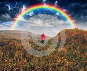 rainbow over the meadow. tourist enjoys the view