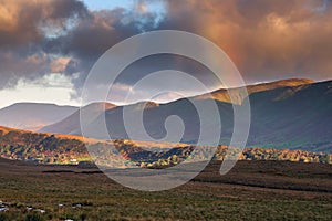 Rainbow over mountains peak in Connemara, county Galway, Ireland. Beautiful landscape scene. Dramatic cloudy sky. Spectacular