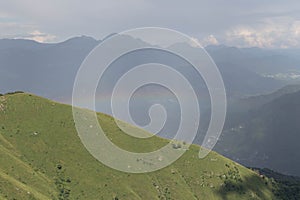 Rainbow over mountains in a sunny day