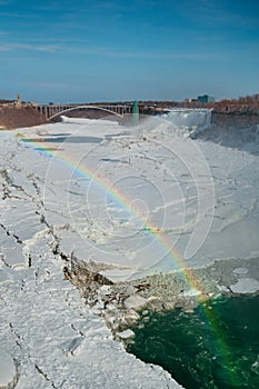 Rainbow over Niagara Falls at winter with a lot of ice and snow