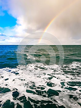 Rainbow over ocean with clearing storm