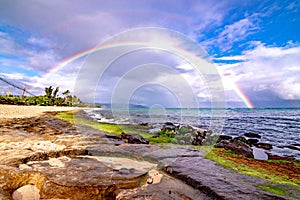 Rainbow over the popular surfing place Sunset Beach , Oahu, Hawaii