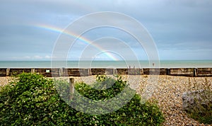 rainbow over the sea behind a pebble beach in dover