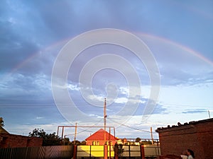 Rainbow over village. Rainbow after rain