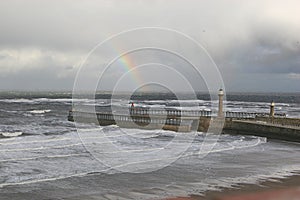 Rainbow over Whitby Harbour piers.