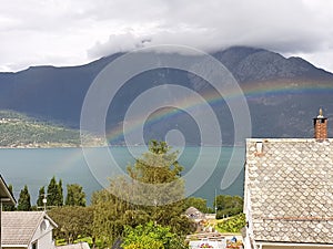 Rainbow panorama lanscape on the beach lake with mountain background with clouds on top