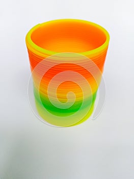 Rainbow plastic coil spring toy on white background