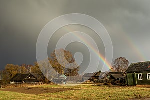 Rainbow after rain over the road and the old village.