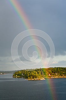 Rainbow in rain during sunshine in sea