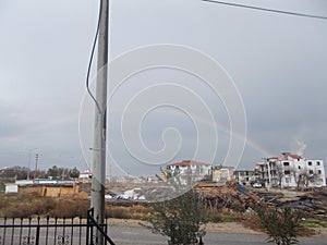 A Rainbow Rising From White Building Seemingly