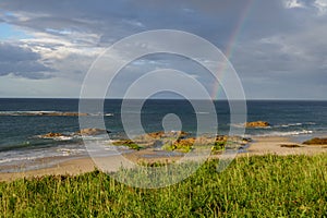Rainbow in sea from Playa Llas in Foz, Lugo, Galicia. Beautiful colorful landscape photo
