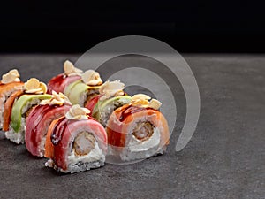 Rainbow seafood sushi roll with Crunchy tempura shrimp, Salmon, tuna, avocado and peanut chips