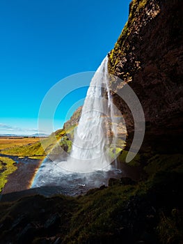 a rainbow shines in the sky at this waterfall and falls