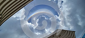 Rainbow sky beach umbrellas cloudy tropical