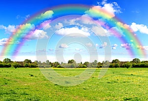 Rainbow sky clouds and grass on meadow