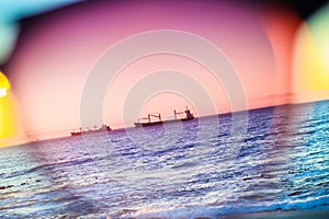 the rainbow sky through the sunglasses, boats in the sea