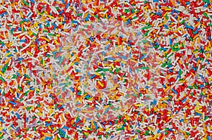 Rainbow sprinkles, colorful sugar sprinkles, background and surface