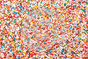 Rainbow sprinkles, rod-shaped colorful sugar sprinkles, background
