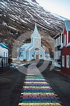 Rainbow stripes on pavement leading up to the Seydisfjordur Church in Iceland