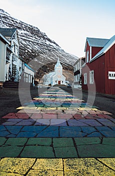 Rainbow stripes on pavement leading up to the Seydisfjordur Church in Iceland