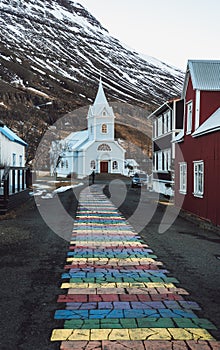 Rainbow stripes on pavement leading up to the Seydisfjordur Church in Iceland