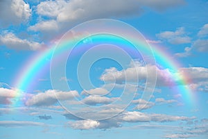 Rainbow. Stunning blue sky rainbow big fluffy clouds with giant arcing rainbow against beautiful summer time blue sky with copy