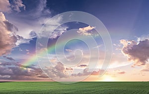 Rainbow sunset on blue sky fluffy white clouds summer   at sea  meadow green grass field nature background landscape